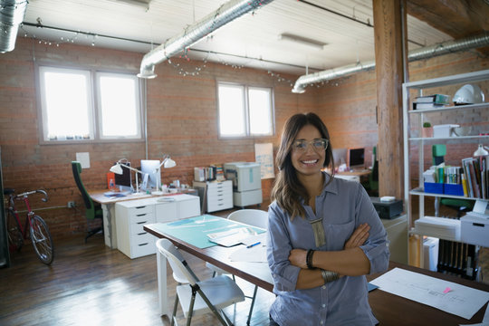 Portrait smiling designer with arms crossed in office