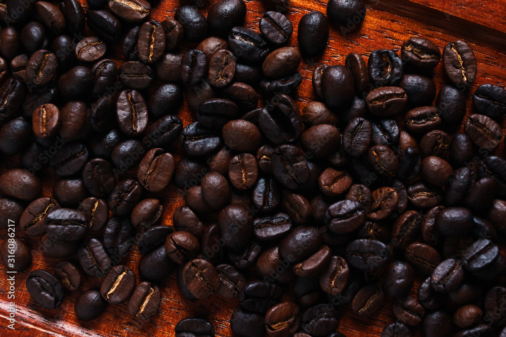 Wall mural Background of the roasted coffee bean on wooden board