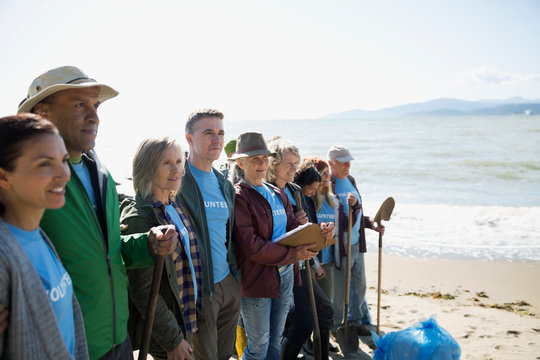 Beach cleanup volunteers standing in a row on beach