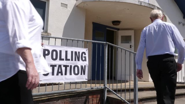 4K: Polling Station Sign - People walking past and going to vote in the election. Politics. Slow Motion