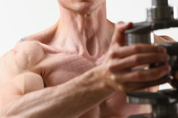 Strong male hands hold the crankshaft against a gray background. Detail of an internal combustion...