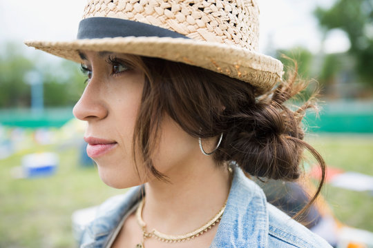 Close up portrait pensive young woman wearing straw hat looking away