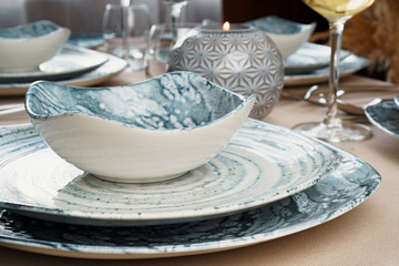 Details of a stylish table setting with textured ceramic dishes