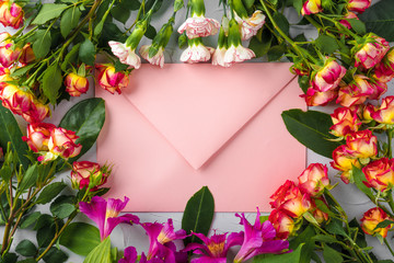 Pink envelope with flowers, top view. Romantic letter