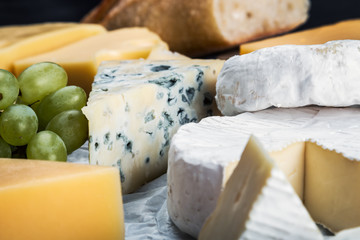 different types of brine, young, soft, hard, rennet and other cheeses with fruit and baguette