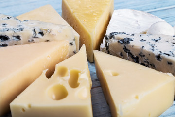assortment of soft, hard, rennet and brine cheeses on a cutting Board