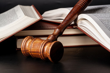 Wooden gavel and juridical books close up