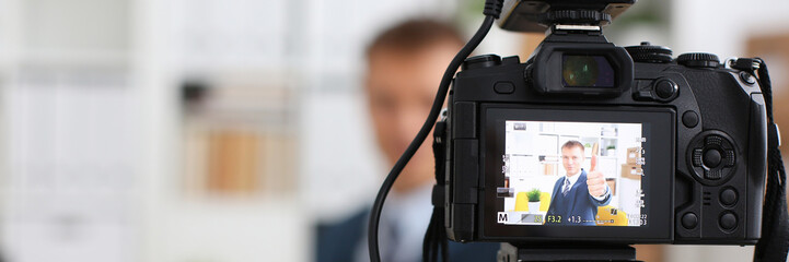 Male in suit and tie show confirm sign arm making promo videoblog or photo session in office...