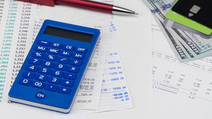 Payment card and calculator on top of supermarket receipt. Shopping and payment concept