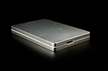 Large-capacity external hard drive with a silver metal casing shot large on a dark background