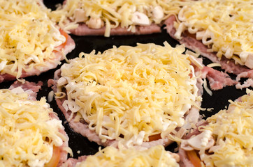 Cooking: chopped pieces of pork, sliced tomatoes, sprinkled with grated cheese and chopped mushrooms