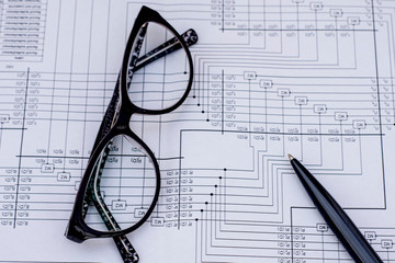 Black pen and glasses lie on a mathematical table