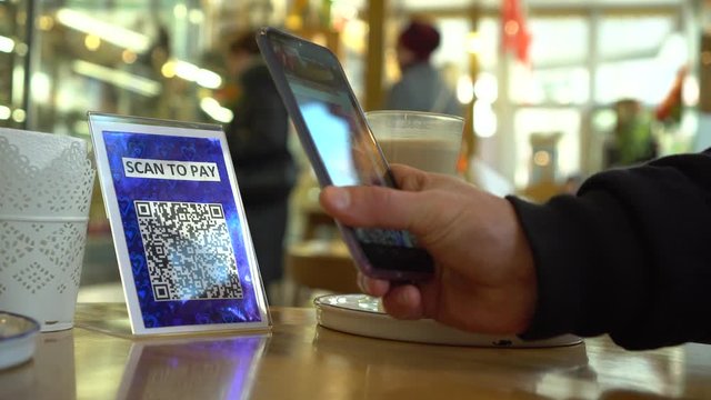 QR code cashless payment. Scan to pay business system in the restaurant, bar and cafe. To use a QR code payment the consumers scans the QR code displayed by the merchant with their phone