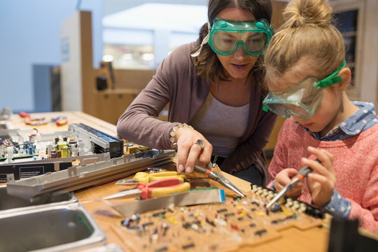 Mother and daughter assembling electronics in science center workshop