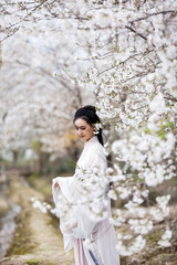 Asian ancient woman enjoying flowers under the plum tree in autumn