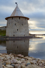 The watchtower of the Pskov Kremlin reflected on the water on the western border of Russia