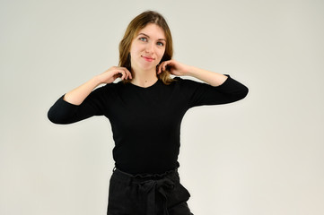 A universal concept, the picture is suitable for any topic. Studio portrait of a pretty blonde girl in a black T-shirt on a white background with bright emotions.