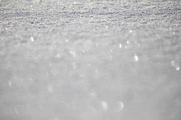 Snow - shallow DOF image of a field covered with fresh snow, splendid play of light can be observed in the snowflakes