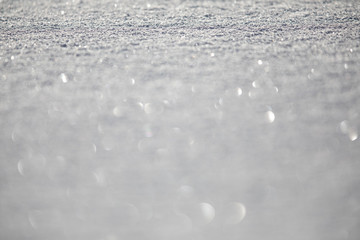 Obraz premium Snow - shallow DOF image of a field covered with fresh snow, splendid play of light can be observed in the snowflakes