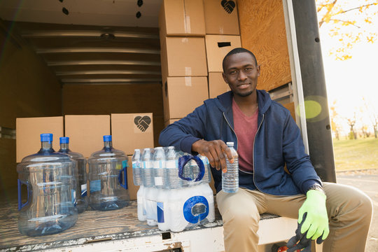 Portrait smiling male volunteer with water on truck