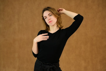 Studio portrait of a pretty blonde girl in a black T-shirt on a beige background with bright emotions. A universal concept, the picture is suitable for any topic. - 316105079