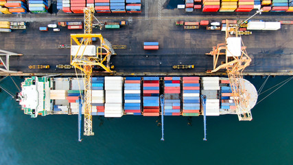 Container ship alongside at container terminal has loading and discharging operations by gantry...