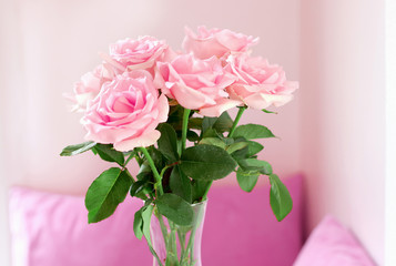 Close up of beautiful bouquet of pink roses in glass vase on table at living room.