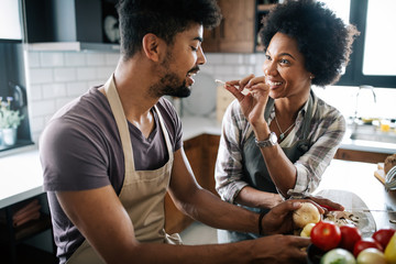 Beautiful young couple cooking healthy food together at home. Having fun in the kitchen.