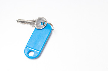 key with a blue tag on a white background, top view