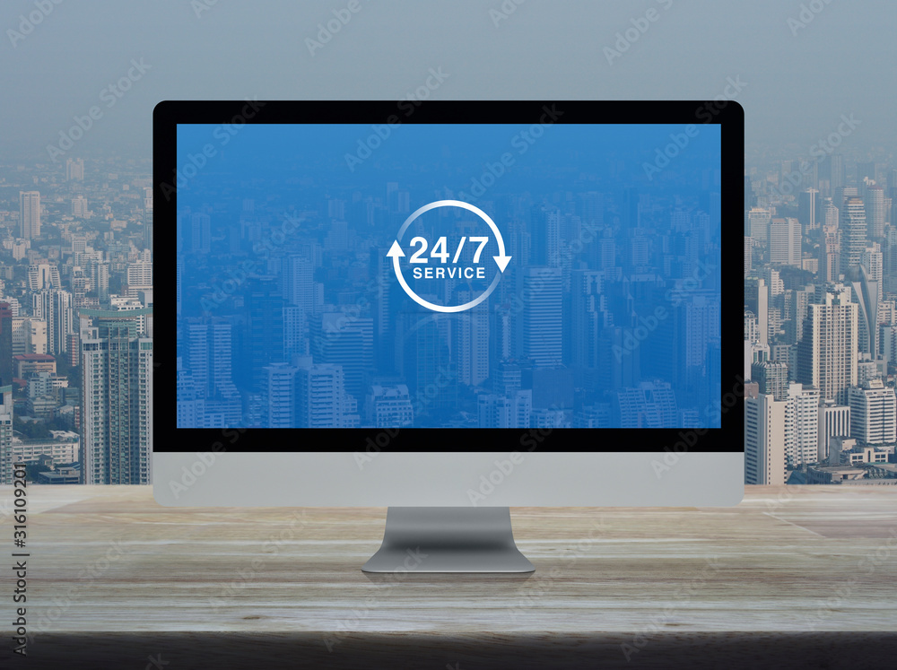 Poster 24 hours service flat icon on desktop modern computer monitor screen on wooden table over office bui