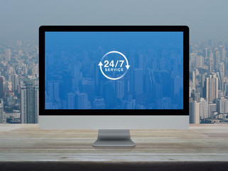 24 hours service flat icon on desktop modern computer monitor screen on wooden table over office...