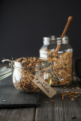 Organic homemade granola cereal with oats, nuts and dried berries. Muesli in a glass jar on the...
