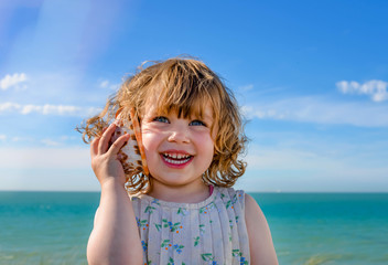 adorable little girl playing with her seashell