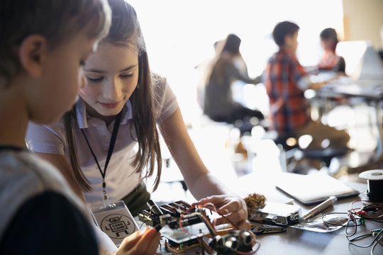 Pre-adolescent boy and girl assembling robotics in classroom