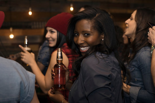 Portrait Smiling Young African American Woman Drinking Beer In Audience At Music Concert
