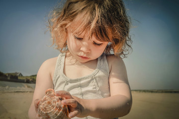 adorable little girl playing with her seashell