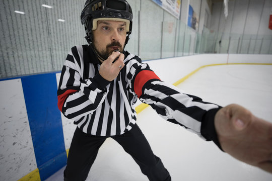 Male Ice Hockey Referee Blowing Whistle On Ice Hockey Rink