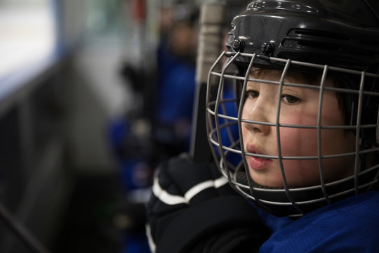 Close up serious boy ice hockey player in helmet looking away