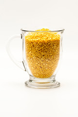 A group of yellow peeled mung bean stay in transparent mug glass