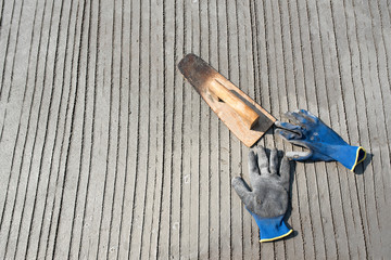 Old wooden trowel on cement. Use a wooden trowel to cut the face for the construction of the building with cement at the construction site.