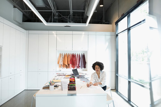 Female Designer Working, Drafting Plans In Conference Room