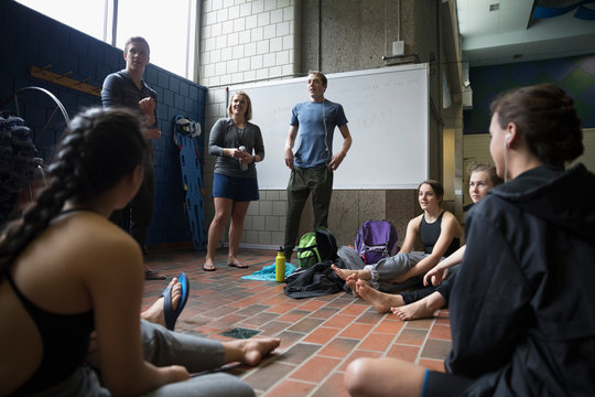 Female Coach Coaching Swimming Team At Practice