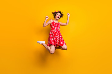 Full length photo of cheerful crazy ecstatic girl win lottery enjoy rejoice victory jump raise fists scream yes wear good look skirt sneakers isolated over bright color background