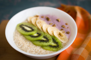 
vegan porridge with fruits. Oatmeal with kiwi and bananas and vegan yogurt. Breakfast. - 316124823