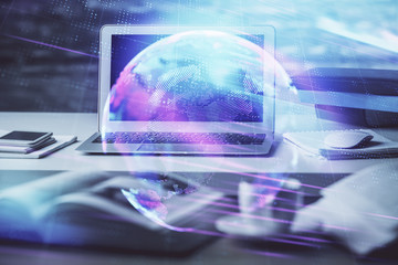 Computer on desktop in office with technology theme hologram. Multi exposure. Tech concept.