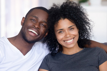 Portrait of happy black couple hugging relaxing at home