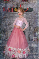 young girl in a pink dress by the fireplace
