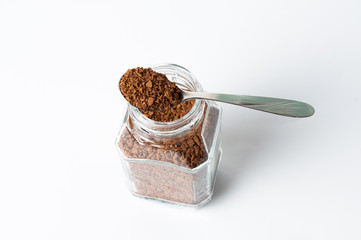Instant coffee in jar and spoon on a white background