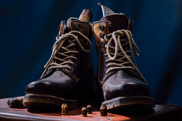 Men's high leather boots rangers on a dark background top view with hunting accessories, symbols of military brutal men