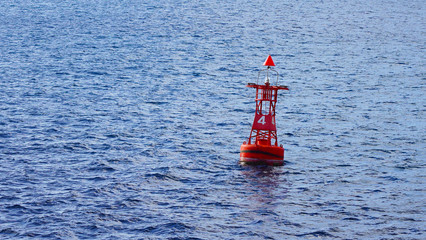 Red coastal buoy in blue ocean water. safety and navigation of ships near the shore © Artem